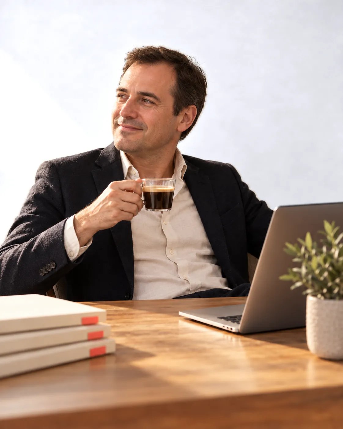 Un chef d’entreprise détendu, un café à la main, bureau rangé